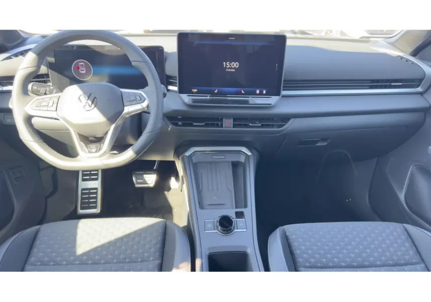 Intérieur du Volkswagen T-Roc noir, vue frontale du poste de conduite avec volant multifonction et écran tactile central.