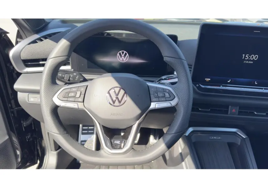 Vue intérieure centrée sur le volant cuir multifonction noir du Volkswagen T-Roc 2026 avec écran digital et console moderne.