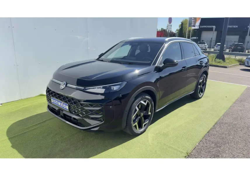 Volkswagen T-Roc noir en 3/4 avant droit, avec jantes 18 pouces et toit panoramique visible sous lumière naturelle.