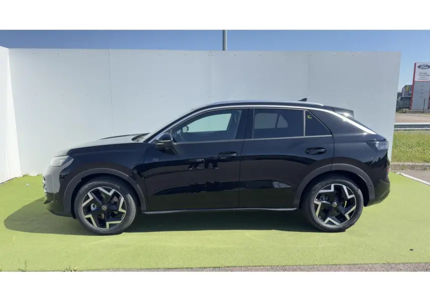Vue de profil côté gauche d'un Volkswagen T-Roc noir avec jantes 18 pouces et toit panoramique.