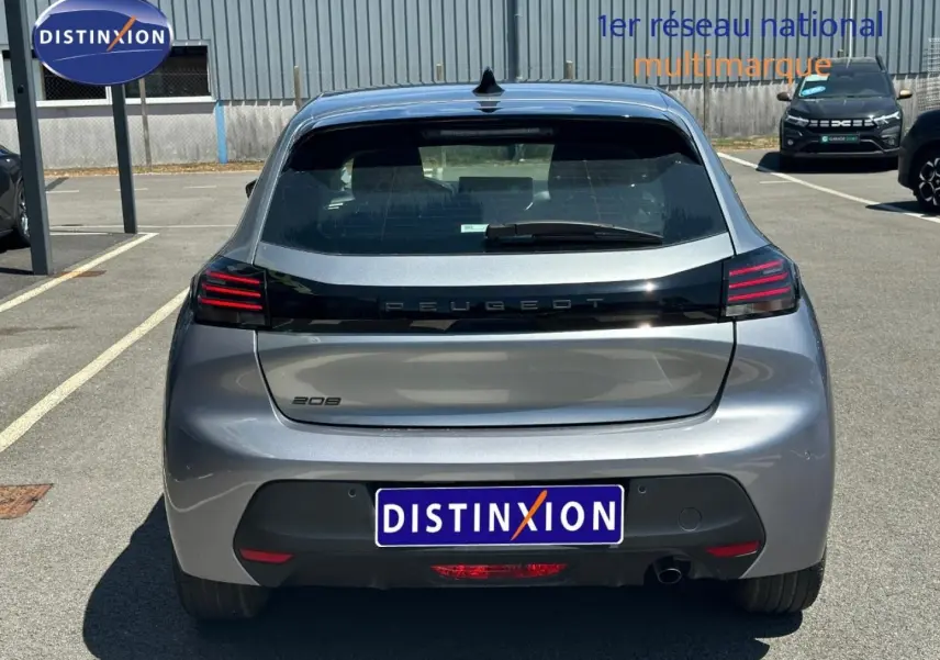 Vue arrière d'une Peugeot 208 gris Artense avec feux arrière LED et logo noir brillant sur le hayon.