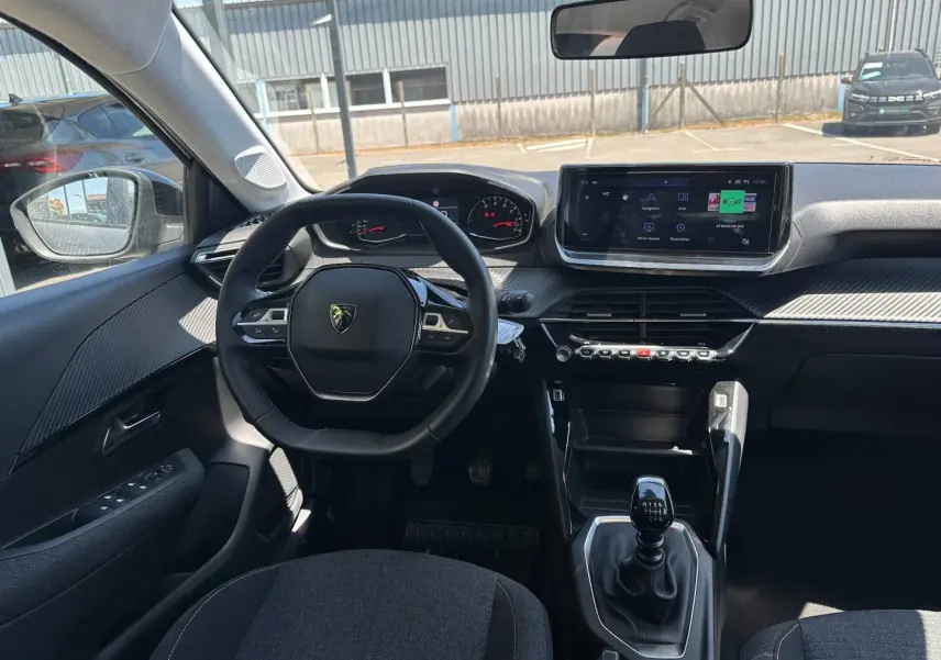 Vue intérieure avant de la Peugeot 208 1.2 100ch Style avec volant compact, écran tactile et levier de vitesses manuel.