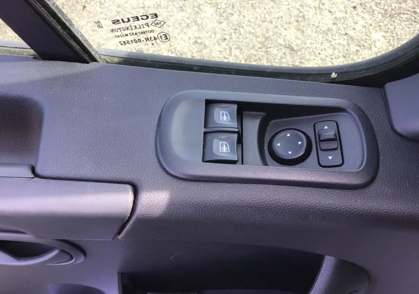 Commandes électriques des vitres et réglage des rétroviseurs sur la porte côté gauche d'un Opel Movano Châssis Cabine blanc 2020.