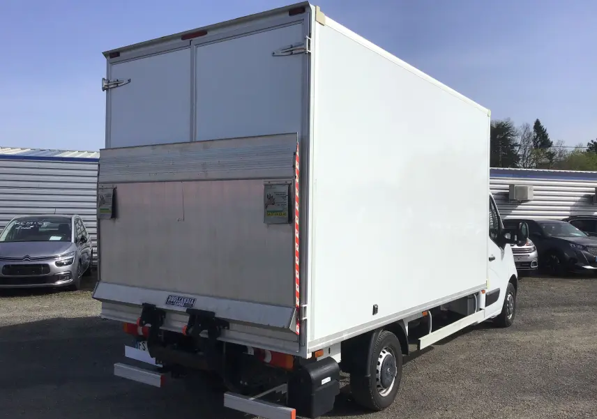 Vue 3/4 arrière droite d’un utilitaire blanc Opel Movano Chassis Cabine avec hayon élévateur métallique déployé.