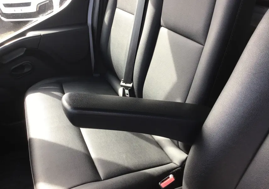 Gros plan sur les sièges avant en cuir noir de l'Opel Movano Châssis Cabine blanc, avec accoudoir central visible.