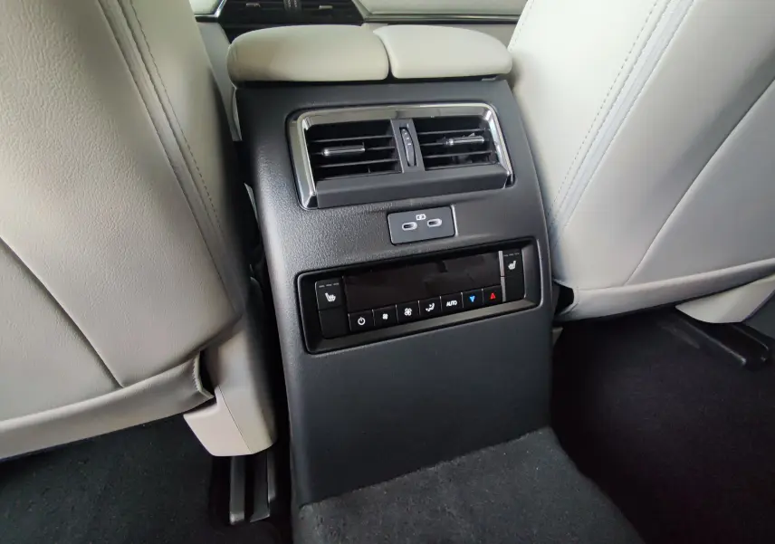 Console arrière avec commandes de climatisation et ports USB du Mazda CX-80 gris foncé, vue centrée entre les sièges avant.