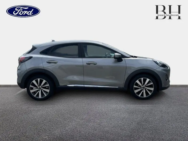 Profil droit d'un Ford Puma gris Solar métallisé 2022 avec jantes alliage et vitres arrière surteintées.