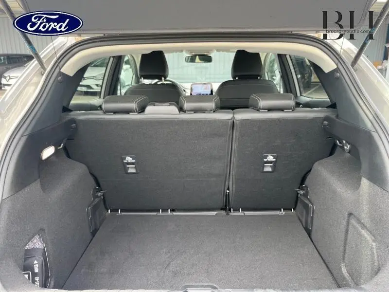 Coffre ouvert vu de l'arrière du Ford Puma gris Solar, montrant la banquette arrière et l'intérieur noir.