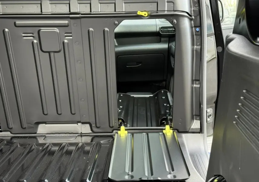 Vue intérieure du coffre du Citroën Berlingo Van 2025 noir Perla avec banquette passager rabattue et tablette écritoire visible.