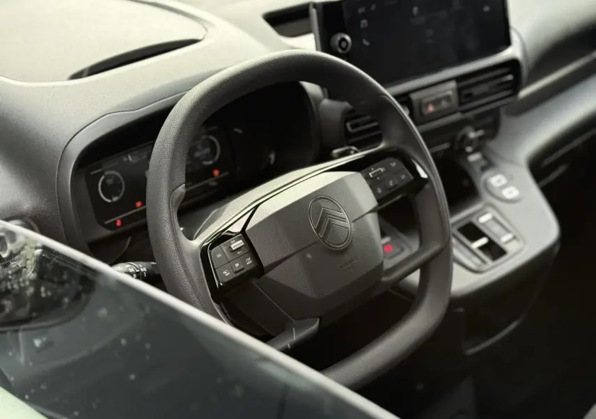 Vue rapprochée du volant multifonctions noir et du tableau de bord digital du Citroën Berlingo Van 2025.