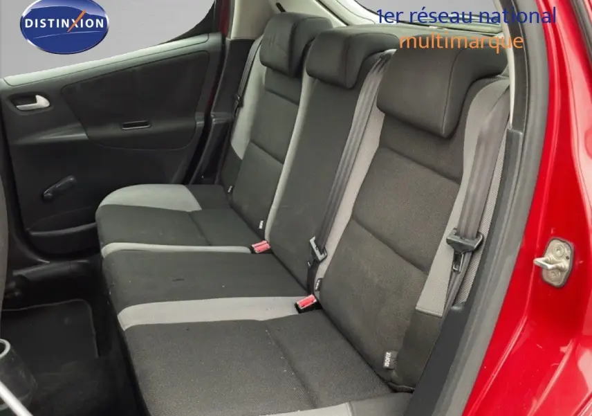 Vue intérieure côté droit sur la banquette arrière en tissu noir et gris d'une Peugeot 207 rouge métallisé 5 portes.