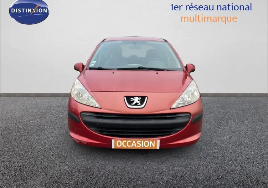 Vue avant d'une Peugeot 207 rouge métal de 2009 avec calandre noire et logo lion bien visible.