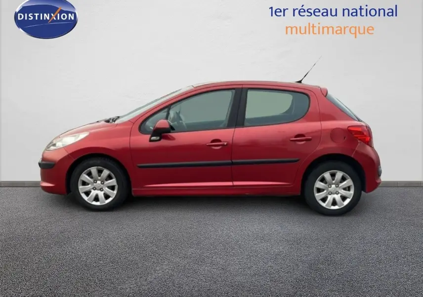 Profil côté gauche d'une Peugeot 207 rouge métal 5 portes de 2009, version HDI 70CH TREND avec jantes alliage.