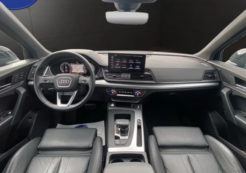 Vue intérieure avant de l'Audi Q5 Business Edition S-Line 2022, avec tableau de bord numérique et sièges sport cuir noir.