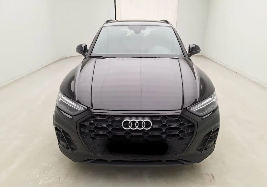 Audi Q5 Business Edition S-Line noir vue de face, mettant en valeur la calandre hexagonale et les phares LED à matrice.