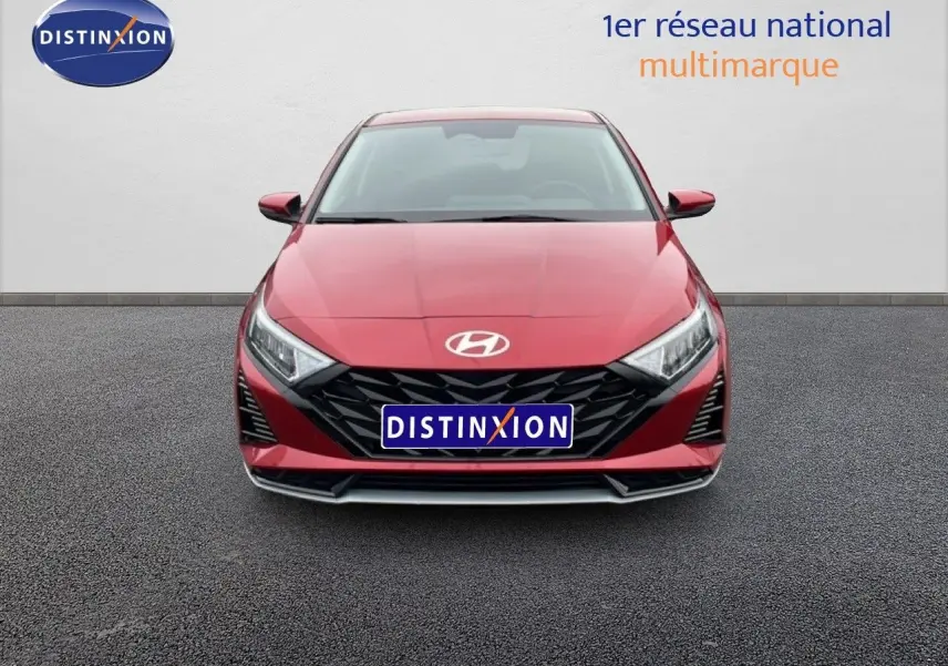 Vue frontale d'une Hyundai i20 2025 rouge Dragon Metal avec calandre noire et phares LED anguleux.