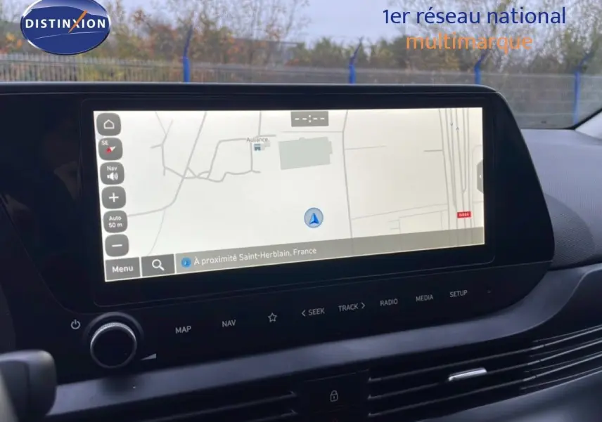 Vue intérieure centrée sur l'écran tactile du système de navigation de la Hyundai i20 rouge Dragon Metal 2025.