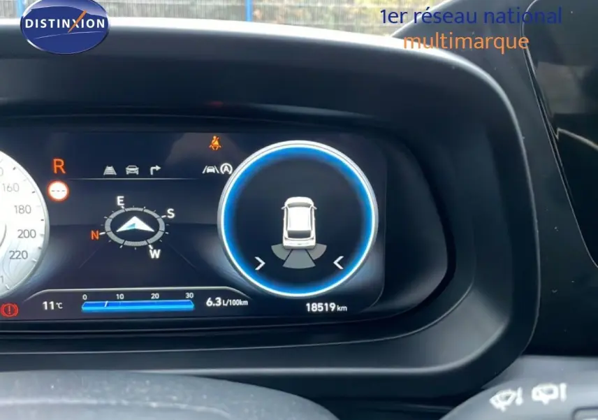 Affichage numérique du tableau de bord de la Hyundai i20 rouge Dragon Metal, montrant la caméra de recul et la consommation.