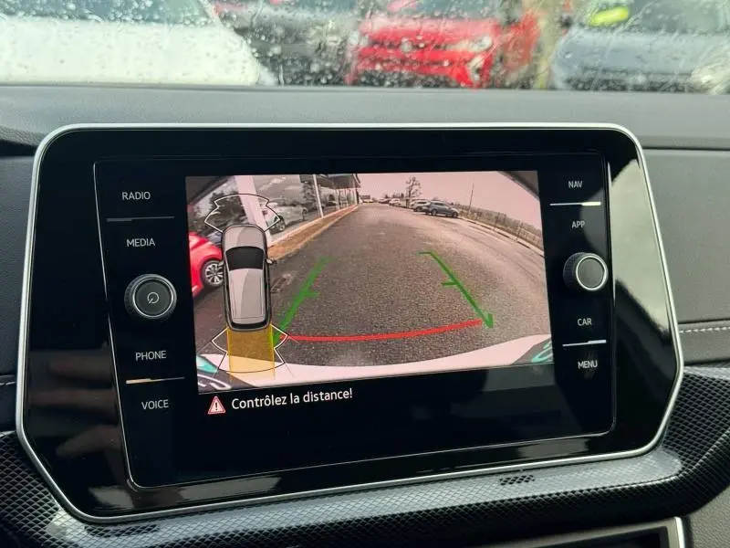 Vue de l'écran multimédia du Volkswagen T-Cross blanc Pur 2025 montrant la caméra de recul avec guidage de trajectoire.
