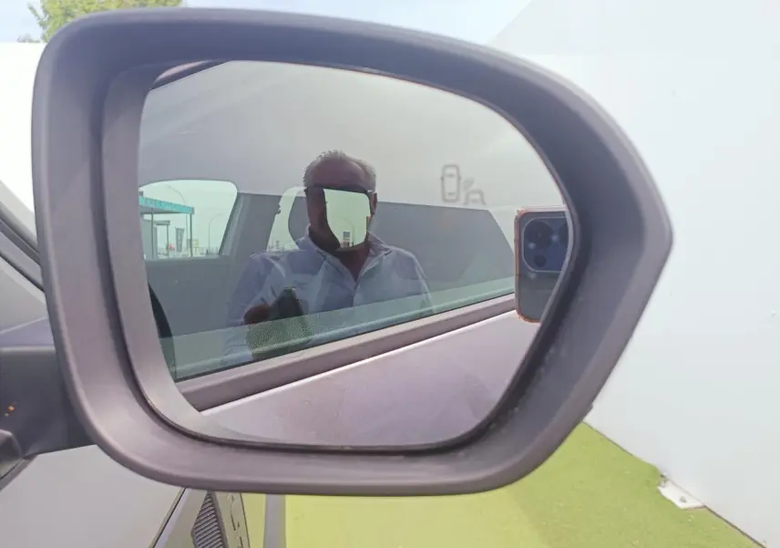 Rétroviseur extérieur côté droit du Dacia Duster gris schiste métal, avec reflet partiel de l'habitacle.