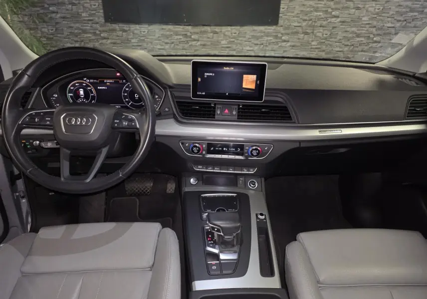 Intérieur Audi Q5 S line 2019 vu de face, tableau de bord noir et sièges cuir gris Roche.