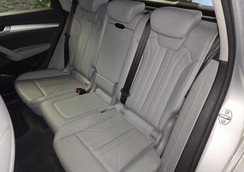 Vue latérale des sièges arrière en cuir gris Roche de l'Audi Q5 hybride rechargeable 2019, avec accoudoir central déplié.