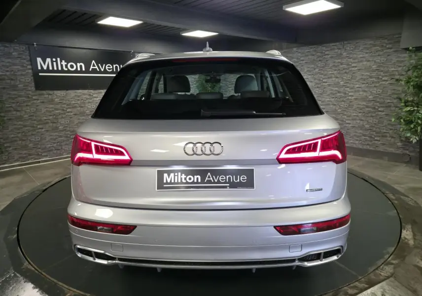 Vue arrière d'un Audi Q5 gris métallisé avec feux LED dynamiques et double sortie d'échappement intégrée.