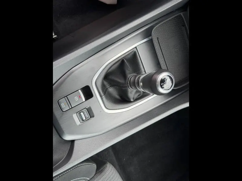 Gros plan sur le levier de vitesse manuel noir avec soufflet cuir dans le Nissan Qashqai blanc nacré 2025.