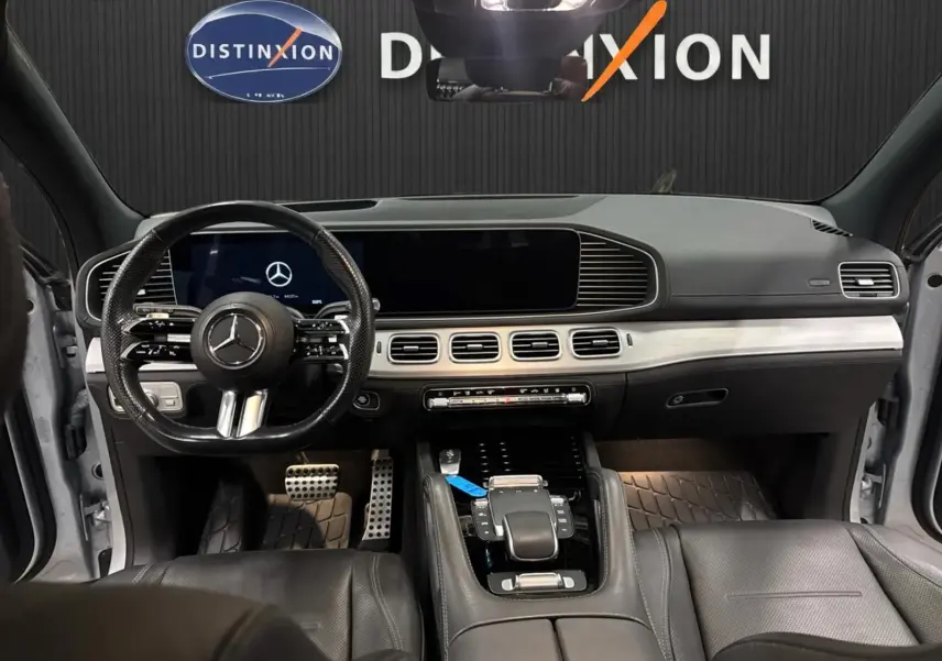 Vue intérieure avant du Mercedes GLE 400 E Hybrid AMG Line 2023, tableau de bord moderne avec cuir noir et écran large.