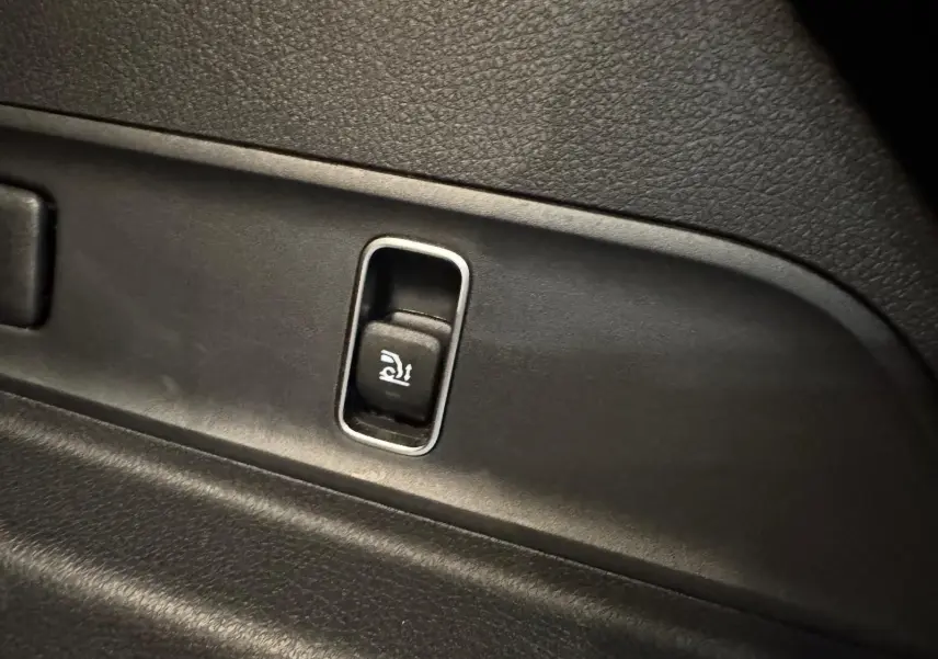 Détail du bouton d'ouverture électrique du hayon sur l'intérieur noir d'un Mercedes GLE 400 E HYBRID AMG 2023.