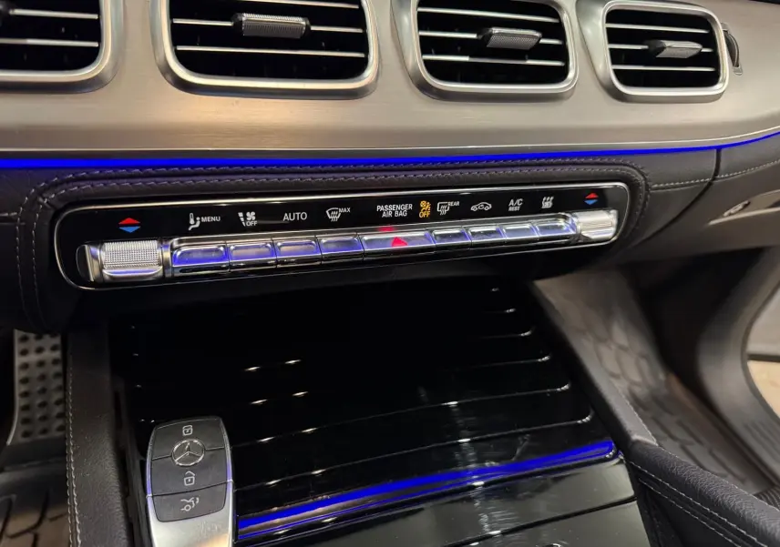Détail de la console centrale du Mercedes GLE 400 E Hybrid AMG Line 2023, avec éclairage d’ambiance bleu et finitions argentées.