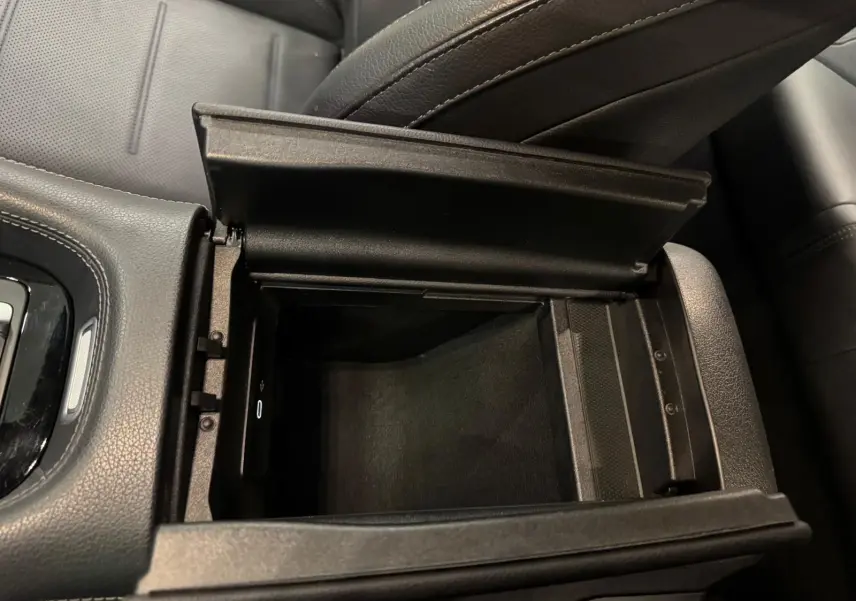 Vue rapprochée de la console centrale ouverte en cuir noir dans un Mercedes GLE 400 E Hybrid AMG Line 2023.