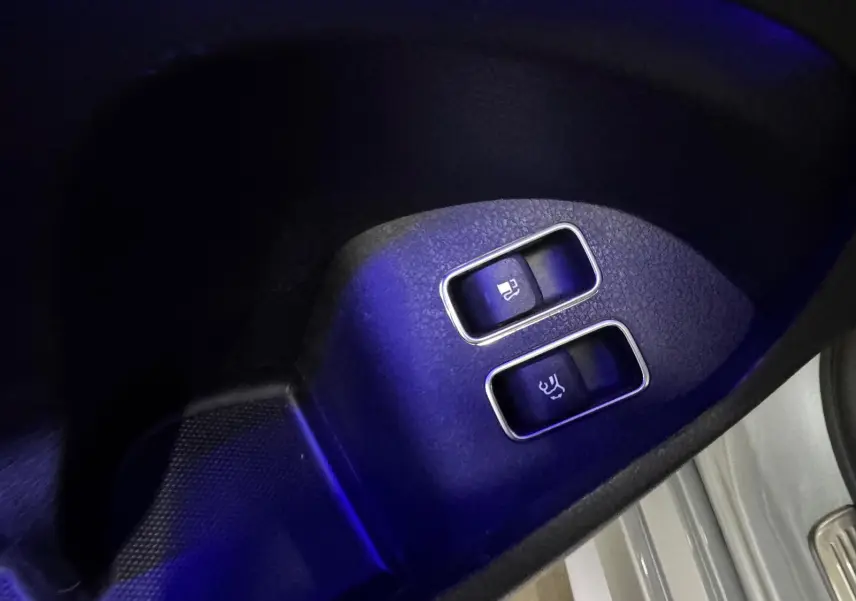 Gros plan sur les boutons d’ouverture du hayon et du coffre, intérieur noir du Mercedes GLE 400 E Hybrid argent.