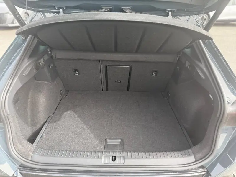 Coffre ouvert vu de l'arrière d'un CUPRA Formentor bleu, montrant un espace de chargement propre et spacieux.