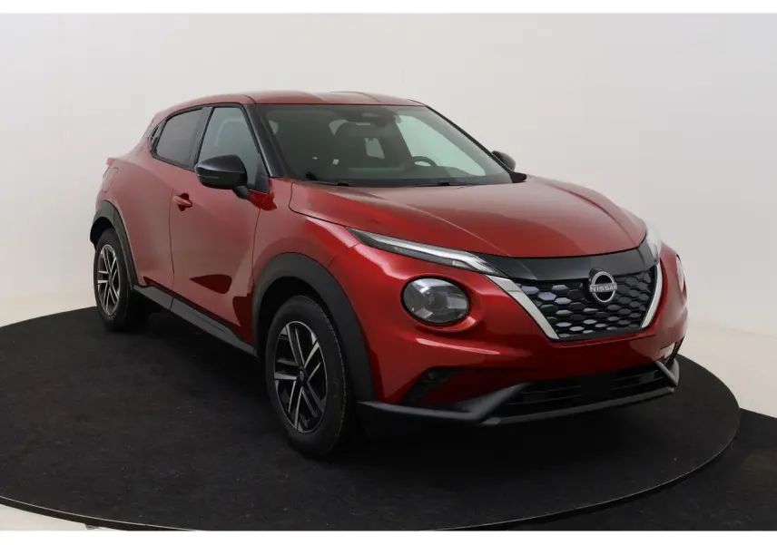 Nissan Juke 2026 rouge Fuji Sunset en 3/4 avant droit, avec calandre noire et jantes alliage 17 pouces.