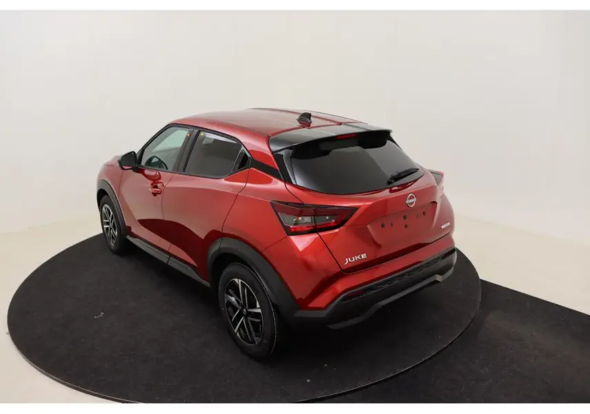 Vue 3/4 arrière droite du Nissan Juke 2026 rouge Fuji Sunset avec jantes alliage et vitres teintées.