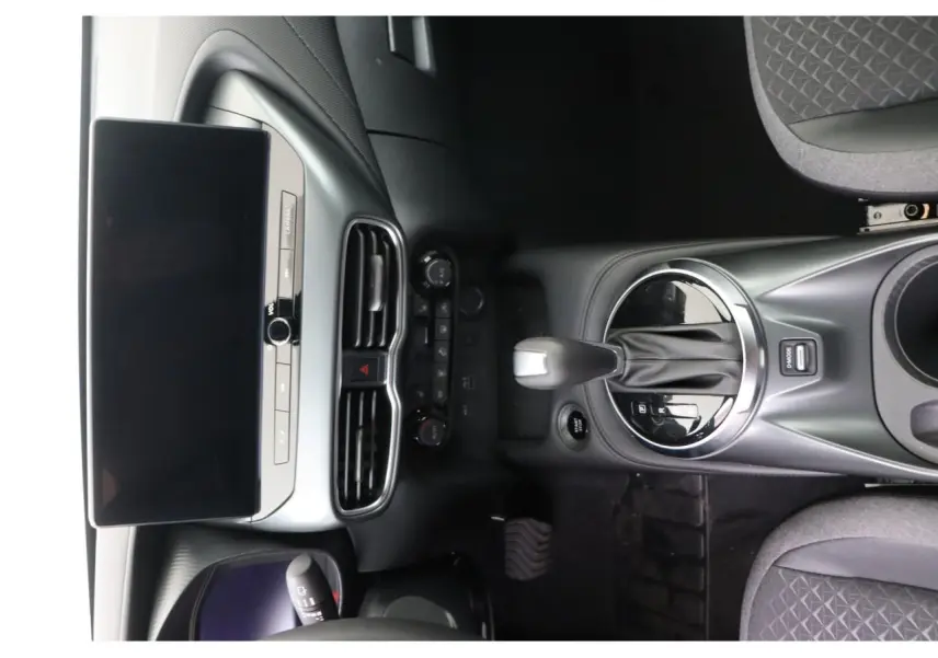 Vue plongeante sur la console centrale et l’écran tactile du Nissan Juke 1.6 Hybrid, intérieur noir moderne.
