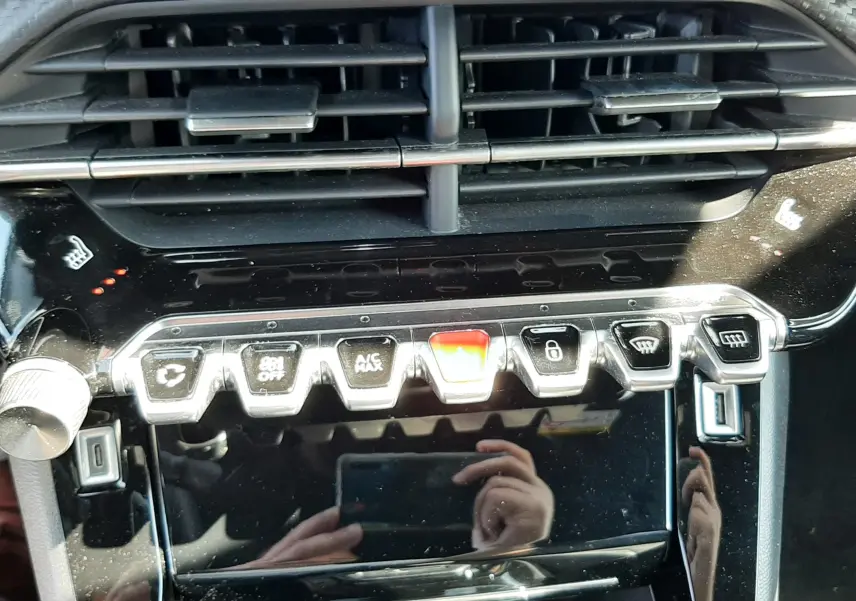 Vue rapprochée de la console centrale noire brillante du Peugeot 2008 1.5 BlueHDi 130ch avec commandes tactiles et aérateurs.