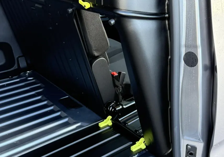 Détail intérieur montrant la cloison et la banquette rabattable du Citroën Berlingo Van gris Artense côté droit