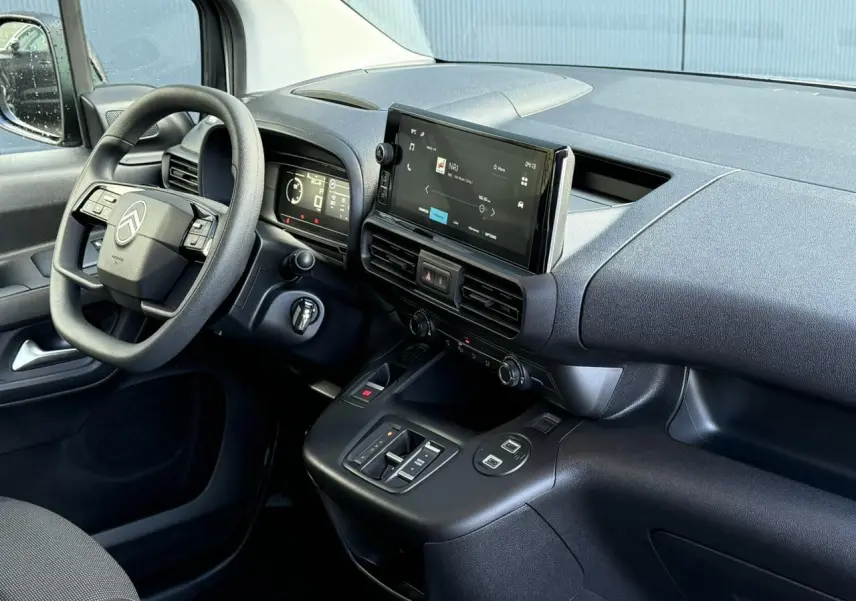 Intérieur du Citroën Berlingo 2025 vu côté conducteur, tableau de bord noir avec écran tactile 10 pouces central.