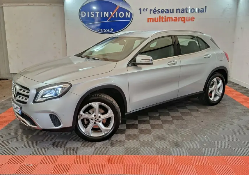 Mercedes GLA 200 d Business gris clair vue 3/4 avant droit, avec jantes alliage et feux LED allumés en intérieur showroom.