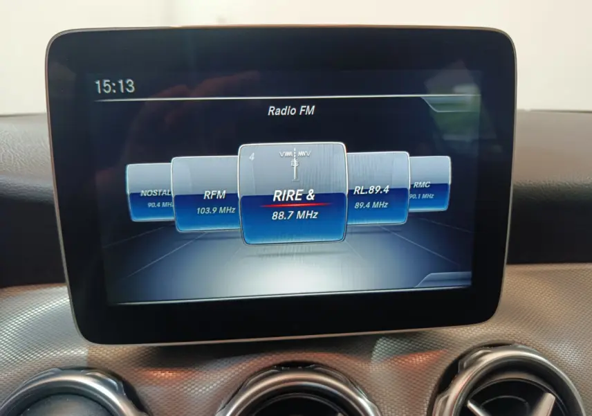 Écran central tactile affichant la radio FM dans l'habitacle du Mercedes GLA 200 d gris clair, vue de face rapprochée.