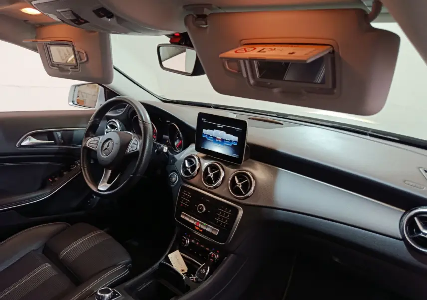 Intérieur noir du Mercedes GLA 200 d 2018 vu côté conducteur, tableau de bord avec écran central et volant cuir multi-fonctions.