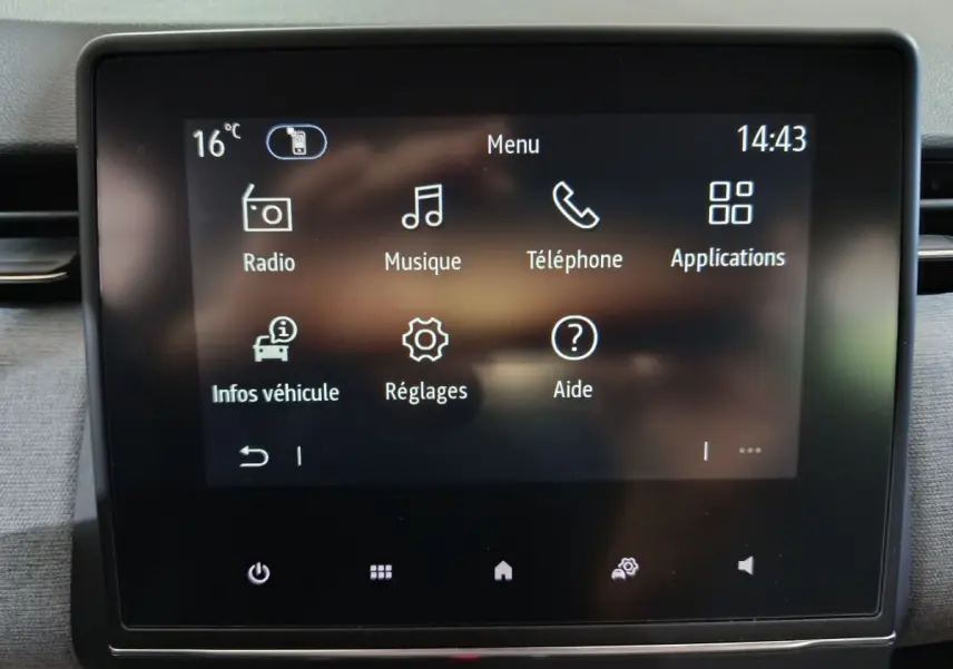 Écran tactile central de la Renault Clio gris clair, affichant le menu principal avec options radio, musique et téléphone.