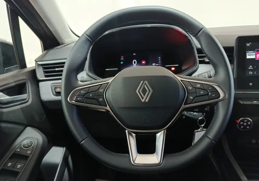 Vue rapprochée du volant cuir noir de la Renault Clio 2025 avec commandes multifonctions et tableau de bord numérique.