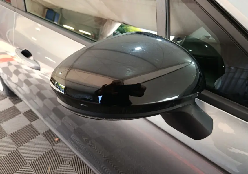 Rétroviseur noir côté gauche d'une Renault Clio gris clair Evolution Blue dCi 100, vue rapprochée en intérieur.