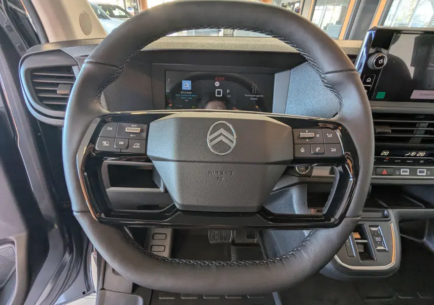 Vue rapprochée du volant cuir noir du Citroën Jumpy Cabine Approfondie gris titane avec tableau de bord digital.