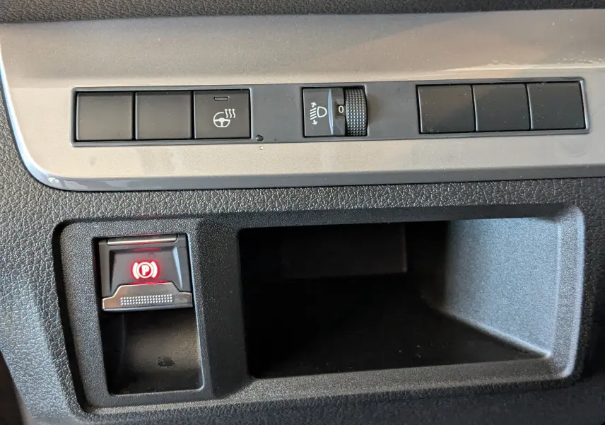 Gros plan sur les commandes intérieures du Citroën Jumpy Cabine Approfondie gris titane, avec bouton de frein à main électrique allumé.