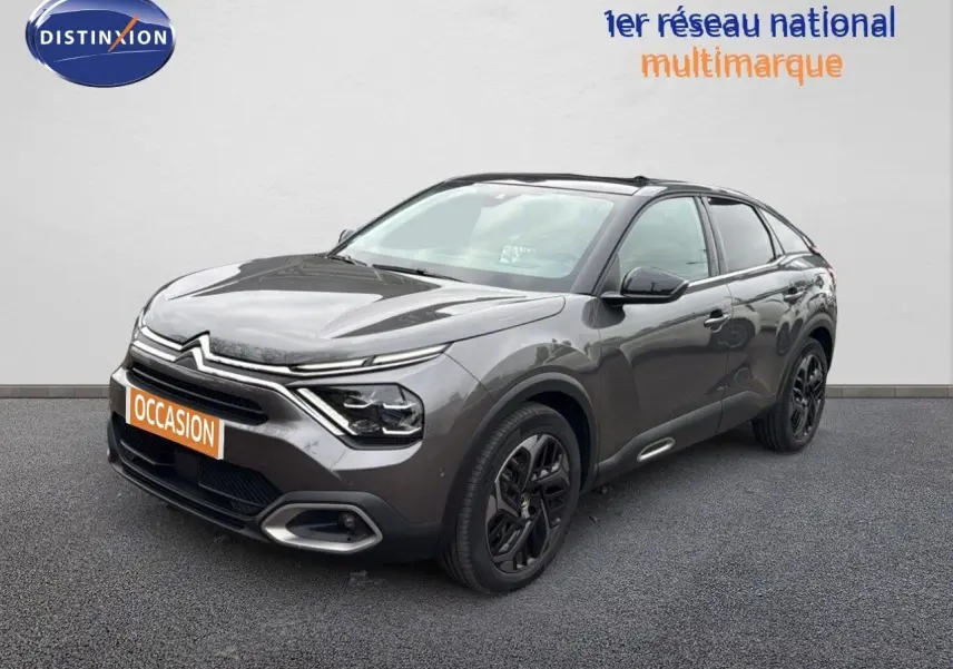 Citroën C4 gris en 3/4 avant droit, avec jantes noires et signature lumineuse LED distinctive.