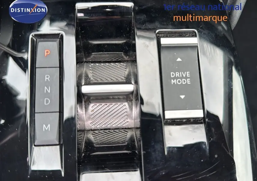 Gros plan sur la console centrale noire brillante de la Citroën C4 1.2 PureTech avec sélecteur de boîte auto et bouton Drive Mode.